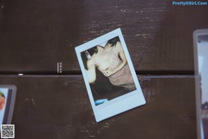 A couple of polaroids sitting on top of a wooden table.