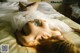 A woman laying on a bed with a bubble in her mouth.