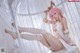 A woman with pink hair is sitting in a cage.